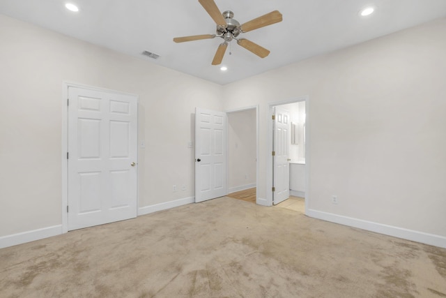 unfurnished bedroom with light carpet, ensuite bathroom, and ceiling fan