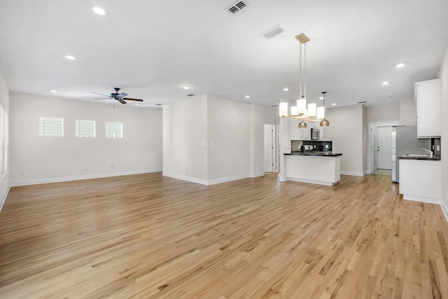 unfurnished living room featuring ceiling fan and light hardwood / wood-style floors