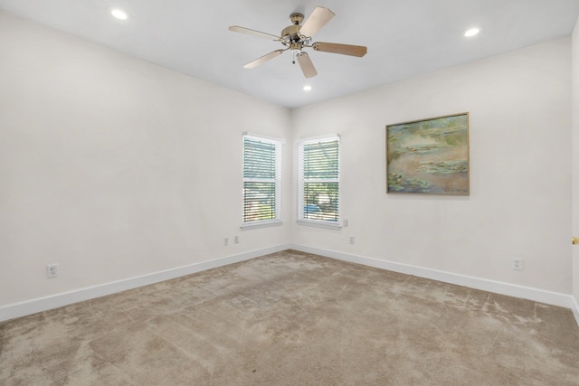 carpeted spare room featuring ceiling fan