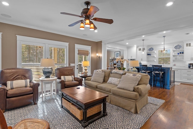 living room featuring crown molding, plenty of natural light, and light hardwood / wood-style floors