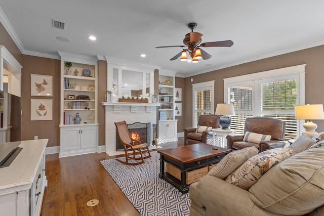 living room with dark wood-type flooring, a fireplace, ornamental molding, and ceiling fan