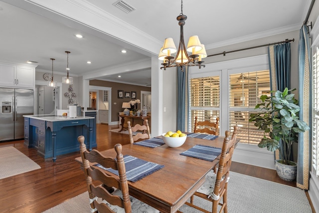 dining space featuring an inviting chandelier, ornamental molding, and dark hardwood / wood-style flooring