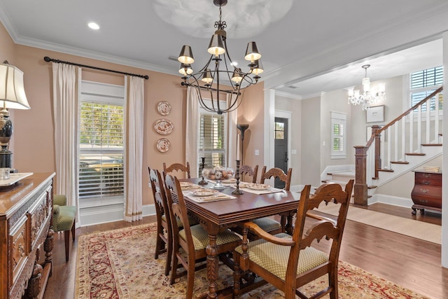 dining room featuring an inviting chandelier, plenty of natural light, ornamental molding, and light wood-type flooring