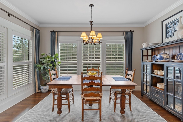 dining area featuring dark hardwood / wood-style flooring, ornamental molding, and an inviting chandelier