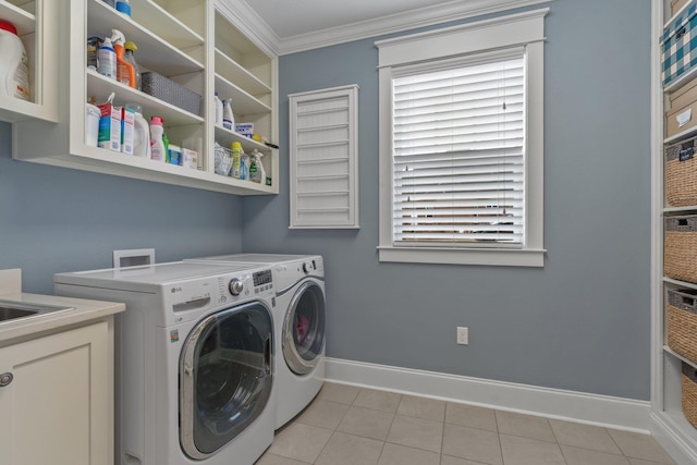 washroom with crown molding, plenty of natural light, washer and dryer, and light tile patterned floors