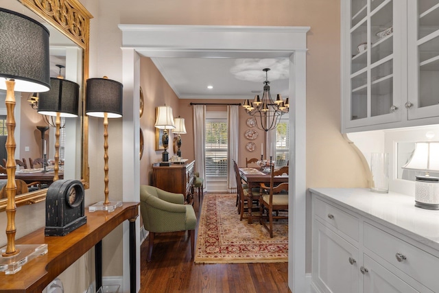 interior space featuring ornamental molding, dark wood-type flooring, and an inviting chandelier