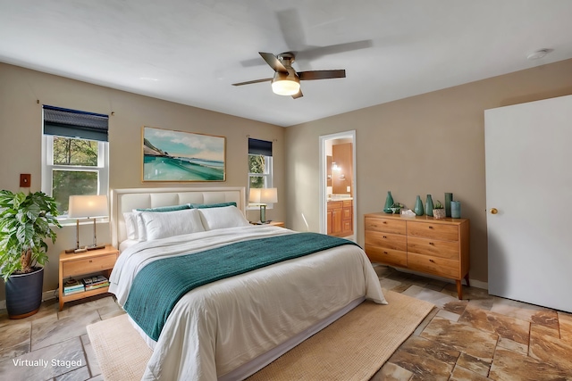 bedroom with stone finish flooring, multiple windows, and baseboards