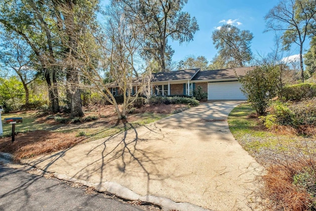 view of front facade featuring an attached garage, concrete driveway, and brick siding