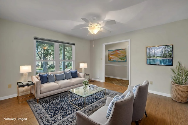 living room featuring wood finished floors, a ceiling fan, and baseboards