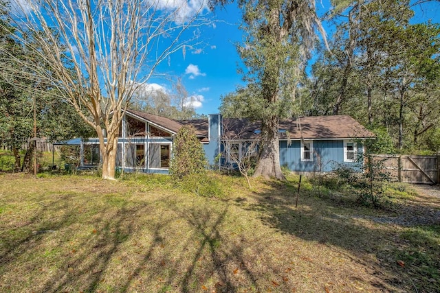 back of house with a lawn and fence