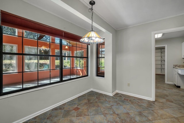 unfurnished dining area featuring baseboards and crown molding