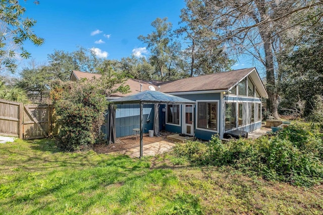 back of house with a yard, a sunroom, and fence