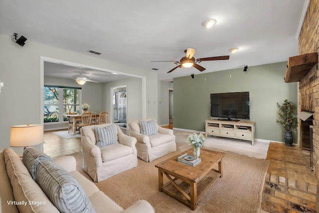 living area featuring visible vents, ceiling fan, and baseboards