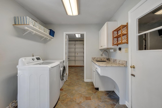 laundry room featuring separate washer and dryer, a sink, cabinet space, and baseboards