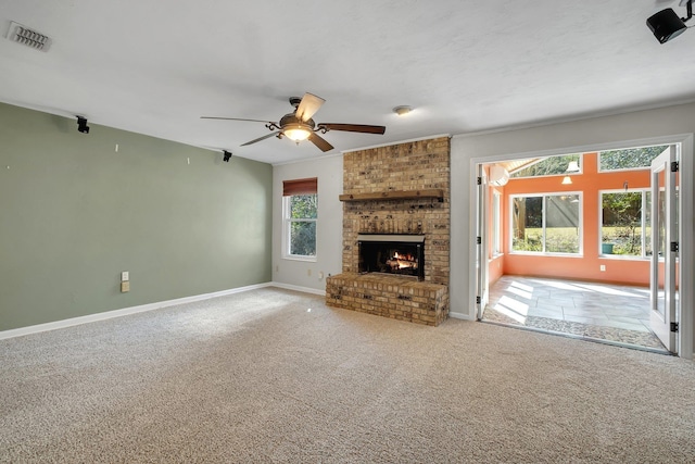 unfurnished living room featuring carpet floors, visible vents, a fireplace, and baseboards