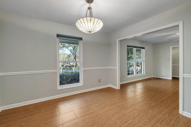 spare room with baseboards and wood finished floors