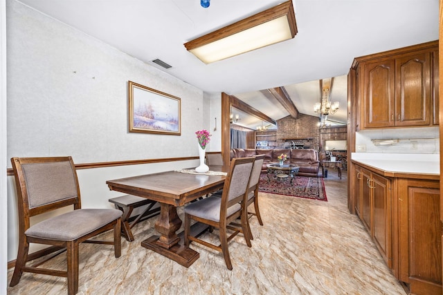 dining room with vaulted ceiling with beams and a notable chandelier