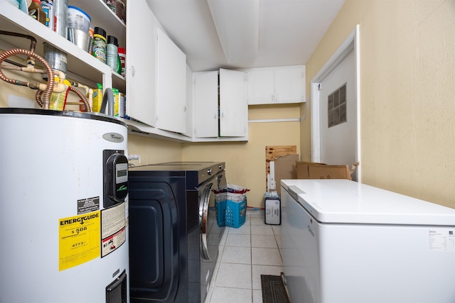 laundry room with cabinets, light tile patterned flooring, washing machine and dryer, and water heater