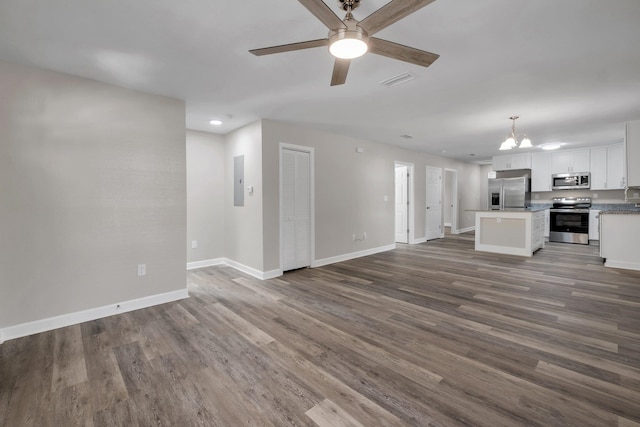 unfurnished living room featuring hardwood / wood-style flooring and ceiling fan with notable chandelier