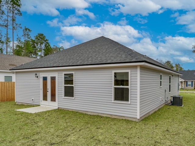 back of property with french doors and a lawn