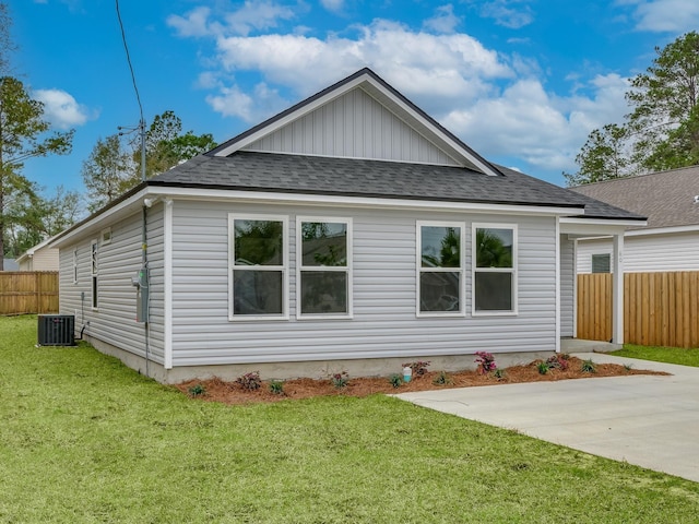 back of property featuring central AC unit and a lawn