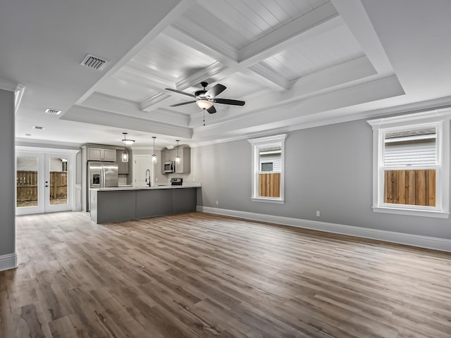 unfurnished living room featuring coffered ceiling, wood-type flooring, ornamental molding, beamed ceiling, and ceiling fan