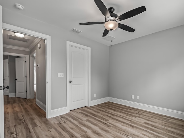 unfurnished bedroom with ceiling fan, ornamental molding, and light hardwood / wood-style floors