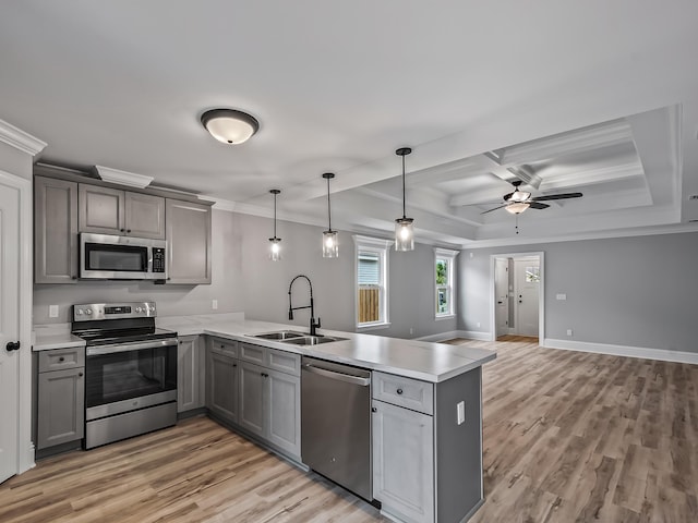 kitchen featuring pendant lighting, sink, stainless steel appliances, coffered ceiling, and kitchen peninsula