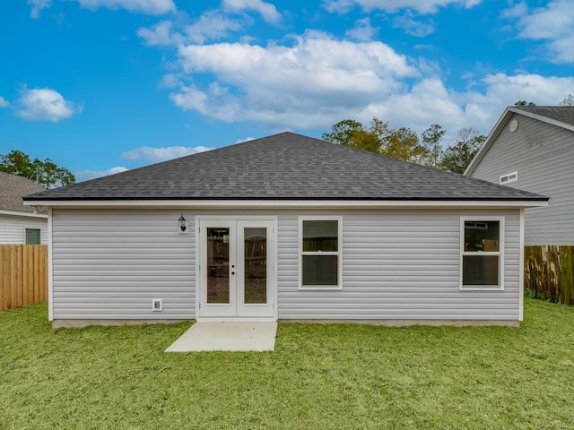 back of property featuring french doors and a lawn