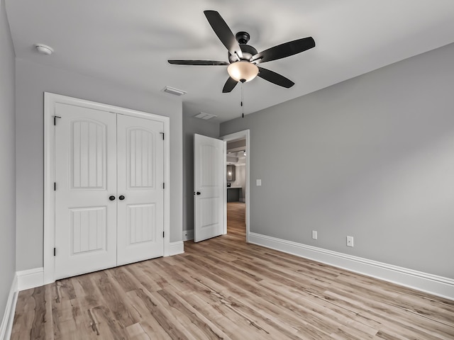 unfurnished bedroom featuring light hardwood / wood-style floors, a closet, and ceiling fan