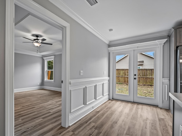 spare room featuring ornamental molding, light hardwood / wood-style floors, ceiling fan, and french doors