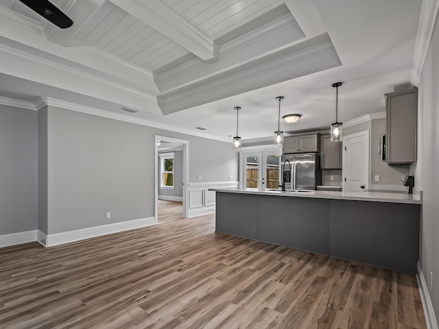 kitchen featuring a raised ceiling, pendant lighting, gray cabinetry, and high end refrigerator