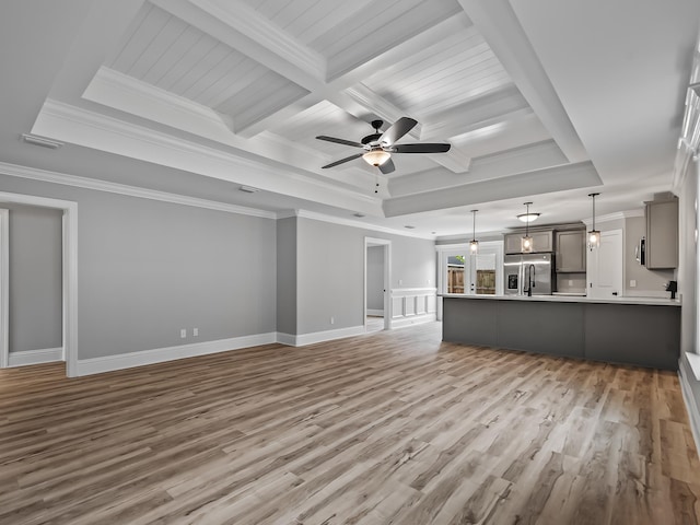 unfurnished living room with ornamental molding, a tray ceiling, and light hardwood / wood-style floors