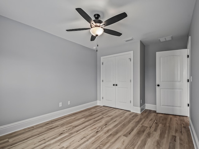 unfurnished bedroom with light hardwood / wood-style floors, a closet, and ceiling fan