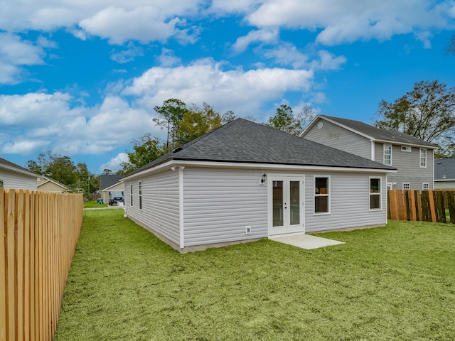 rear view of property featuring a lawn and french doors