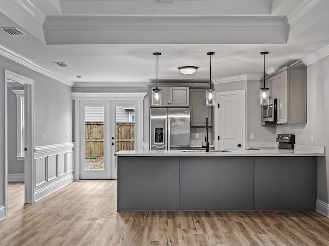 kitchen featuring appliances with stainless steel finishes, pendant lighting, gray cabinetry, kitchen peninsula, and crown molding