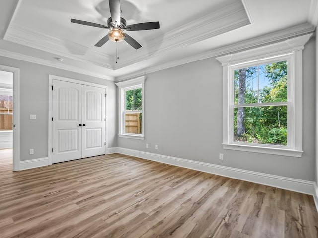 67 Broken Bow Trl, Crawfordville, FL 32327 - unfurnished bedroom featuring a raised ceiling, light wood finished floors, crown molding, baseboards, and a closet
