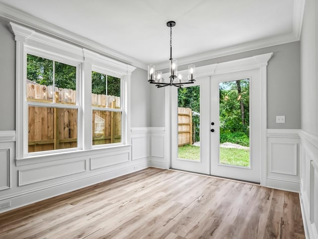 67 Broken Bow Trl, Crawfordville, FL 32327 - unfurnished dining area with a chandelier, wainscoting, a decorative wall, wood finished floors, and crown molding
