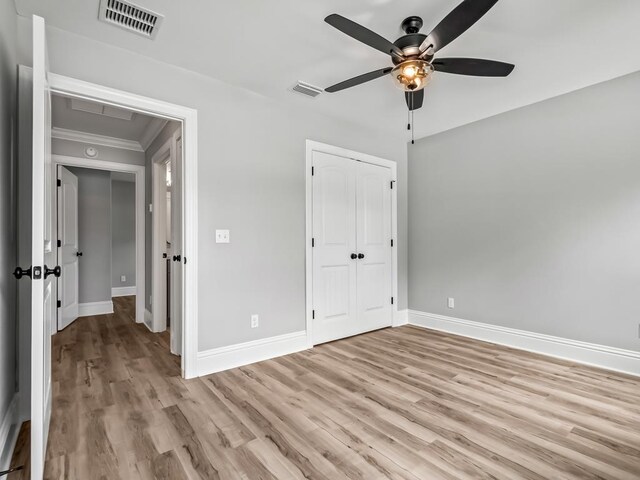67 Broken Bow Trl, Crawfordville, FL 32327 - unfurnished bedroom with baseboards, light wood finished floors, crown molding, and a closet