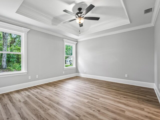 67 Broken Bow Trl, Crawfordville, FL 32327 - empty room featuring a tray ceiling, plenty of natural light, wood finished floors, ornamental molding, and ceiling fan
