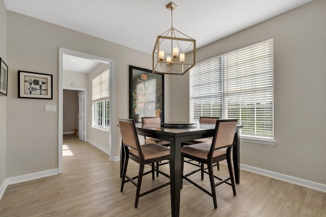 dining space with an inviting chandelier and light hardwood / wood-style flooring