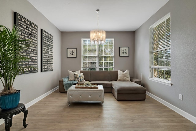 living area with an inviting chandelier and light wood-type flooring