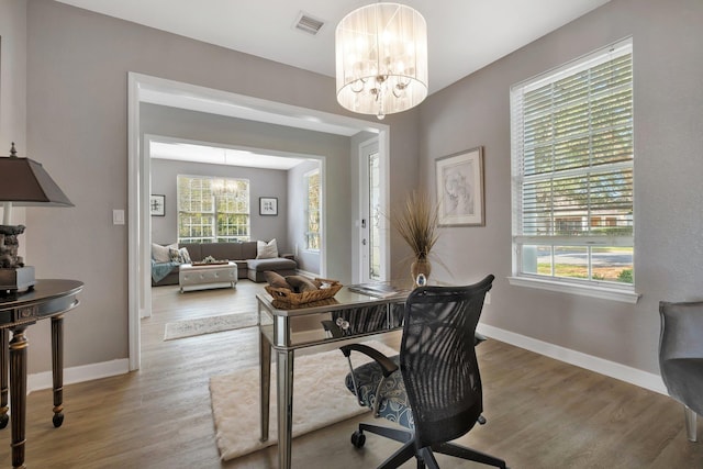 office space featuring a notable chandelier and light hardwood / wood-style flooring