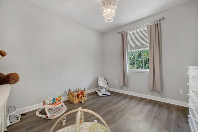 miscellaneous room featuring a notable chandelier and dark hardwood / wood-style flooring