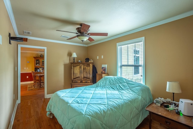 bedroom with ceiling fan, crown molding, and hardwood / wood-style flooring