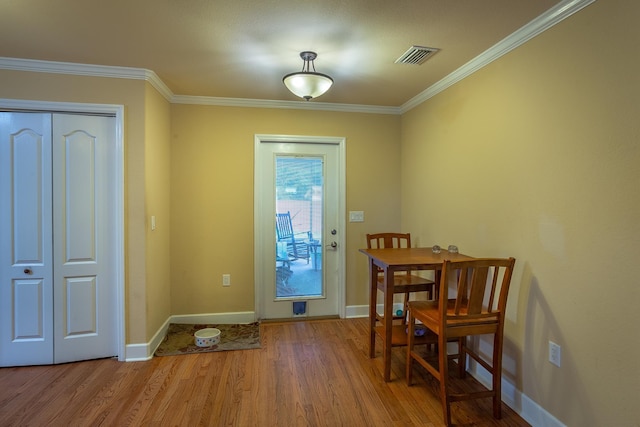 doorway featuring light wood-type flooring and ornamental molding