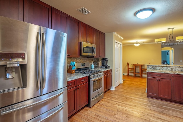 kitchen featuring backsplash, a notable chandelier, light hardwood / wood-style floors, light stone counters, and stainless steel appliances