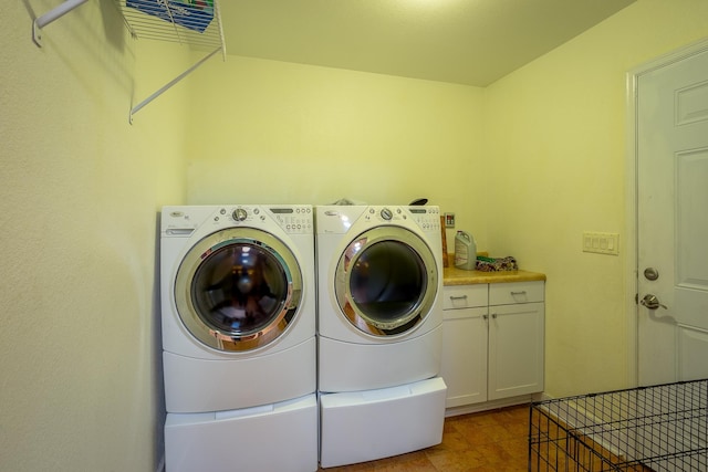 laundry area with washer and dryer and cabinets