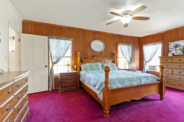 bedroom featuring a textured ceiling, dark colored carpet, and multiple windows