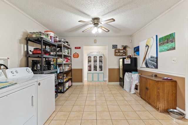 clothes washing area with light tile patterned floors, ceiling fan, washing machine and clothes dryer, a textured ceiling, and crown molding